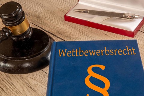 Symbolic image: Competition law textbook next to a judge's gavel