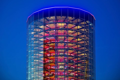 An illuminated car tower with new cars for delivery in the evening, Autostadt, Volkswagen AG,