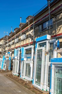Energy-efficient refurbishment of residential buildings, older apartment block is scaffolded, gets