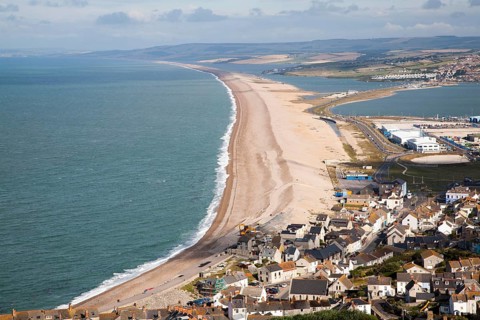 Chesil beach tombolo with housing in Chiswell in the foreground, Isle of Portland, Dorset, England,