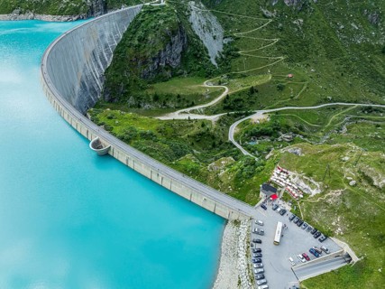 Dam of the Moiry lake, Lac de Moiry, turquoise glacial water, parking lot and restaurant at the