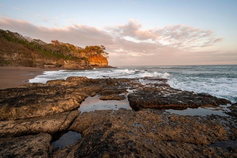 Sandy beach beach with rocks and sea at sunset, Playa Cocalito, coastal landscape, Pacific coast,