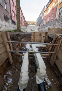 Construction site of a district heating house connection, pipes, insulated, are laid from a central