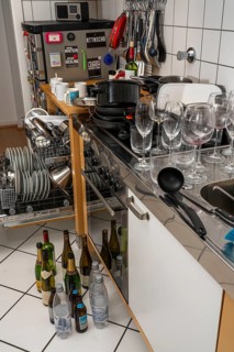 Kitchen after a big dinner, cooking party, dishwasher, full, with cleaned dishes, dirty glasses,