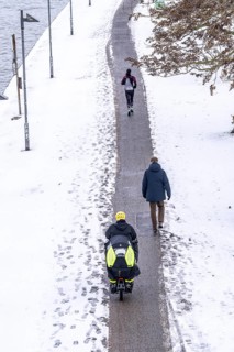 Winter in the city, cleared riverside path on the Main, jogger, walker, cyclist, cargo bike,