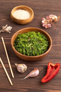 Chuka seaweed salad in wooden bowl on brown wooden background. Side view, close up
