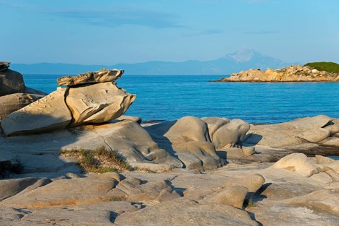 Rocky coast with unique rock formations under a clear sky, Karidi beach, Karydi, Mount Athos in the