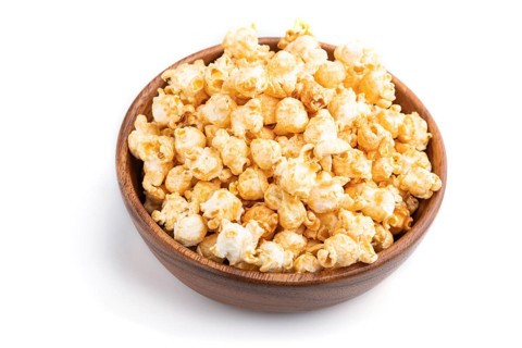 Popcorn with caramel in wooden bowl isolated on white background. Side view, close up