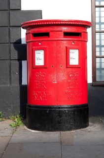 Large red traditional Royal Mail pillar box with two letter box openings, Royal Wootton Bassett,