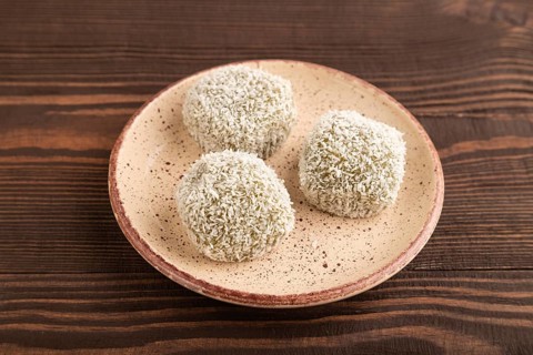 Japanese rice sweet buns mochi filled with pandan and coconut jam on brown wooden background. side