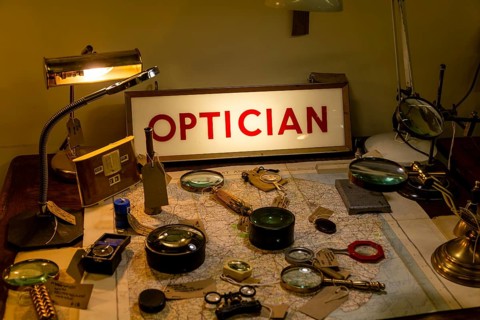 Optical items magnifying glasses labelled for sale with Optician illuminated sign, Marlesford Mill