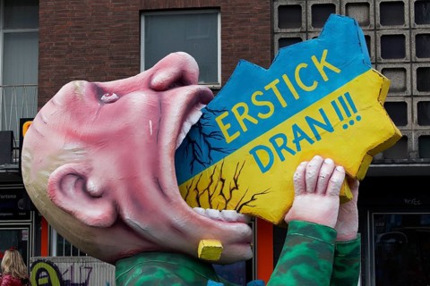 Vladimir Putin with his mouth open, devouring Ukraine, papier-mâché figure, satirical float by