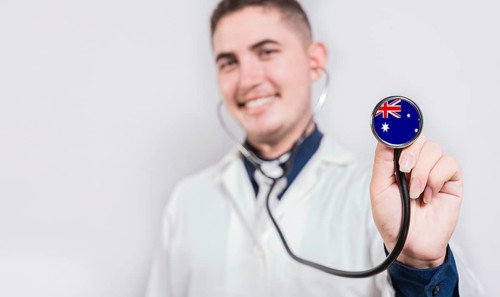 Smiling doctor showing stethoscope with Australia flag. Australia National Healthcare concept