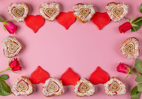Frame made of heart-shaped cupcakes, red hearts and roses, Valentine's Day, pink background