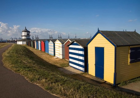 Colourful seaside beach huts and Low lighthouse maritime museum, Harwich, Essex, England, United