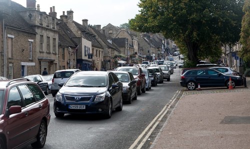 Tourist honeypot village street crowded with traffic in Burford, Oxfordshire, England, UK