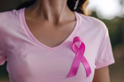 Pink breast cancer awareness ribbon attached to woman's shirt. KI generiert, generiert, AI