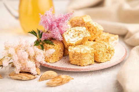 Traditional turkish delight (rahat lokum) with glass of green tea on a gray concrete background and