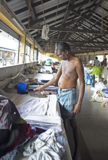 Indian man ironing laundry at Dhoby Khana laundry, Kochi, Kerala, India, Asia