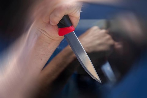 Symbolic image of a knife attack: close-up of a knife in a man's hand