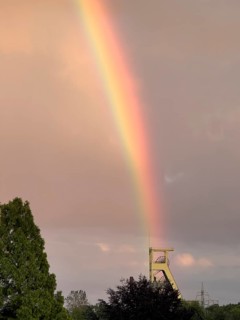 Rainbow stands exactly above former winding tower of closed colliery for coal mining Symbol for the