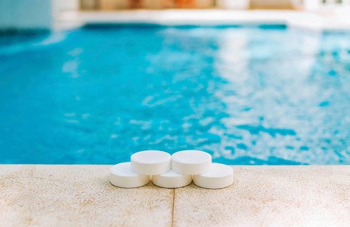 Close up of chlorine tablets on the edge of a swimming pool. Chlorine tablets for swimming pool