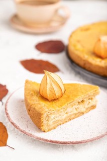 Autumn onion pie decorated with leaves and cup of coffee on gray concrete background. Side view,