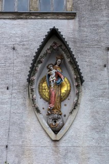 Sculpture of the Mother of God, Mary with the Child Jesus on a residential building facade,