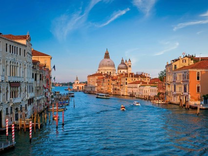 Panorama of Venice Grand Canal with boats and Santa Maria della Salute church on sunset from Ponte