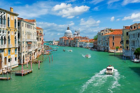 View of Venice Grand Canal with boats and Santa Maria della Salute church in the day from Ponte