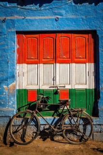 Bicycle and door painted in India national flag colors. Blue city of Jodhpur, Rajasthan, India,