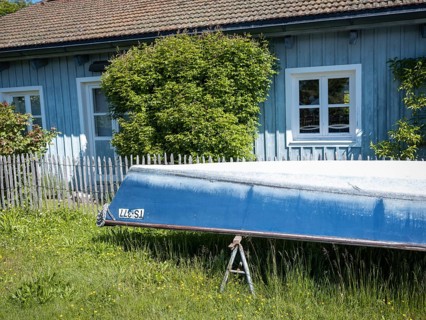 Boat and blue painted house on the Fraueninsel, Chiemsee, Bavaria, Germany, Europe