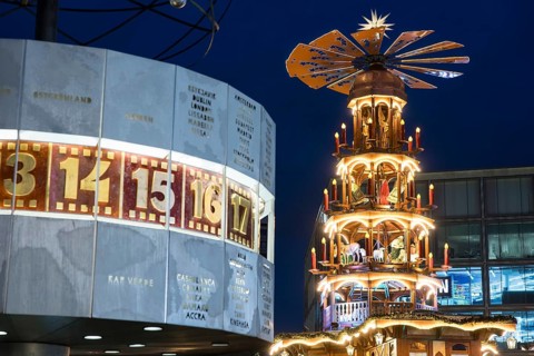 A Christmas pyramid behind the World Time Clock at the Christmas market on Alexanderplatz, Berlin,
