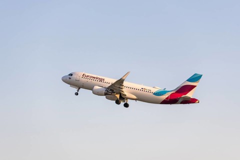 A Eurowings aircraft rises into the blue sky, symbolising the start of a journey,