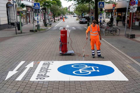 Application of road markings for a cycle lane, Rüttenscheider Straße in Essen, in the shopping and