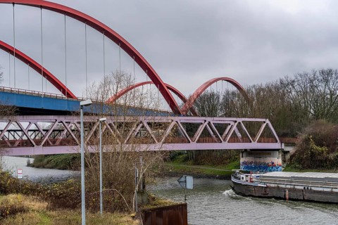 Freighter, dilapidated motorway bridge A42, (red arches) over the Rhine-Herne Canal, with massive