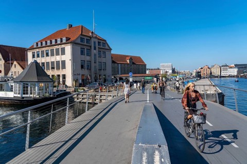 Cyclists on the Inderhavnsbroen cycle and footpath bridge, over the harbour, at Nyhavn, Copenhagen