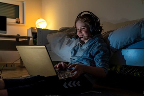 Boy, at home on the computer, laptop, in the children's room, playing a game, chatting with other