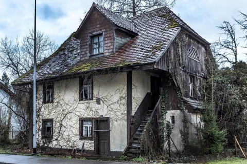 Exterior view of an old house that has been uninhabited for decades and has since been demolished.