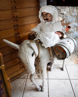 Cloth donkey carrying a male doll and wine barrels, mountain village Langadia, Arcadia,