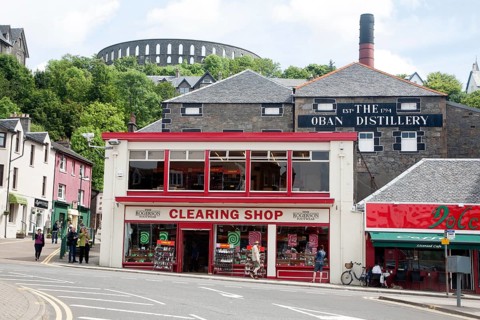 Distillery and shops Oban, Argyll and Bute, Scotland, UK with McCaig's Tower in the background