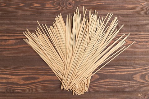 Japanese buckwheat soba noodles on brown wooden background. Top view, flat lay, close up