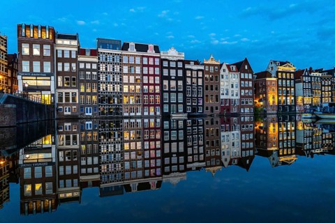 Canal houses on the Damrak, in the centre of the old town of Amsterdam, harbour, starting point of