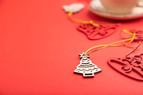 Christmas or New Year composition. Decorations, fir and spruce branches, cup of coffee, on a red