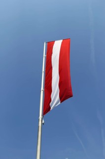 Österreichische Flagge vor blauem Himmel (Austrian flag in front of a blue sky)