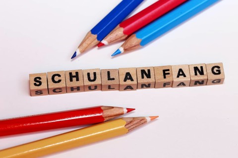 Symbolic image for the start of the new school year with letter cubes and pens