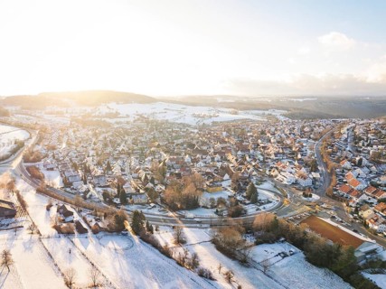 Snow-covered village in a vast landscape with low sun, Calw- Stammheim, Black Forest, Germany,