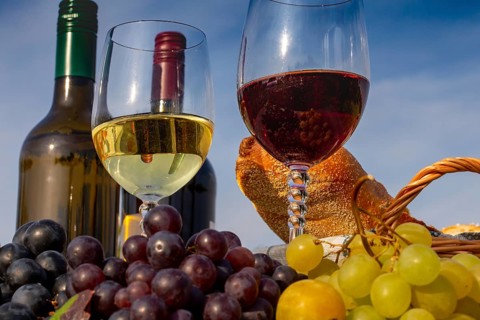 Symbolic image: Ripe grapes decorated with wine glasses on a wooden table