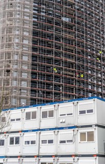 Large construction site, construction of a high-rise residential building, scaffolded shell,