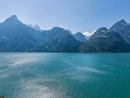Lake Uri, part of Lake Lucerne near Flüelen, windsurfers in front of the mountains of the Alps.